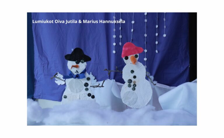 Kaksi lapsen askartelemaa lumiukkoa.
